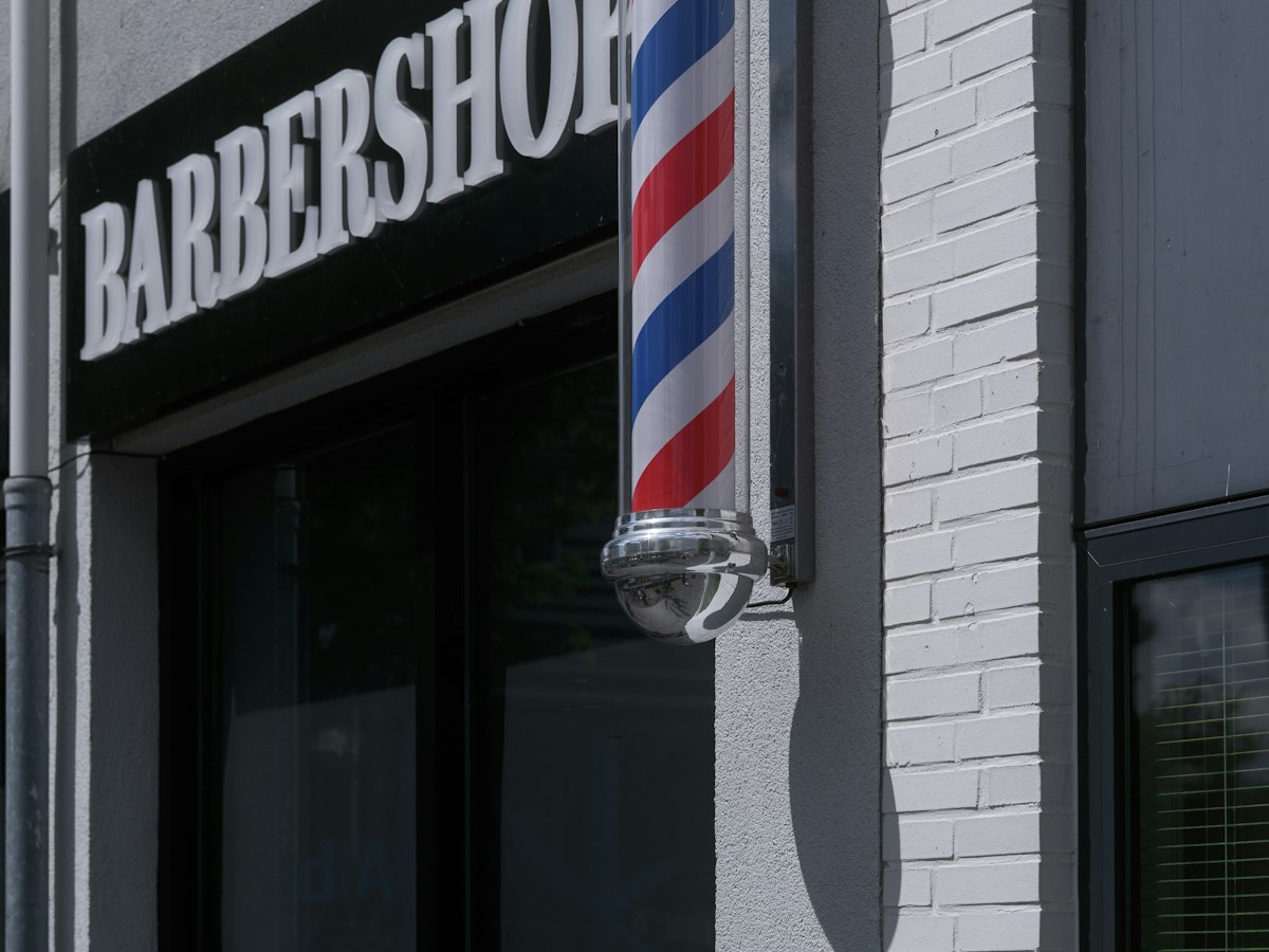 ことり市の理容室BARBER ONE CHAIRの店先。入口にサインポールが回っている